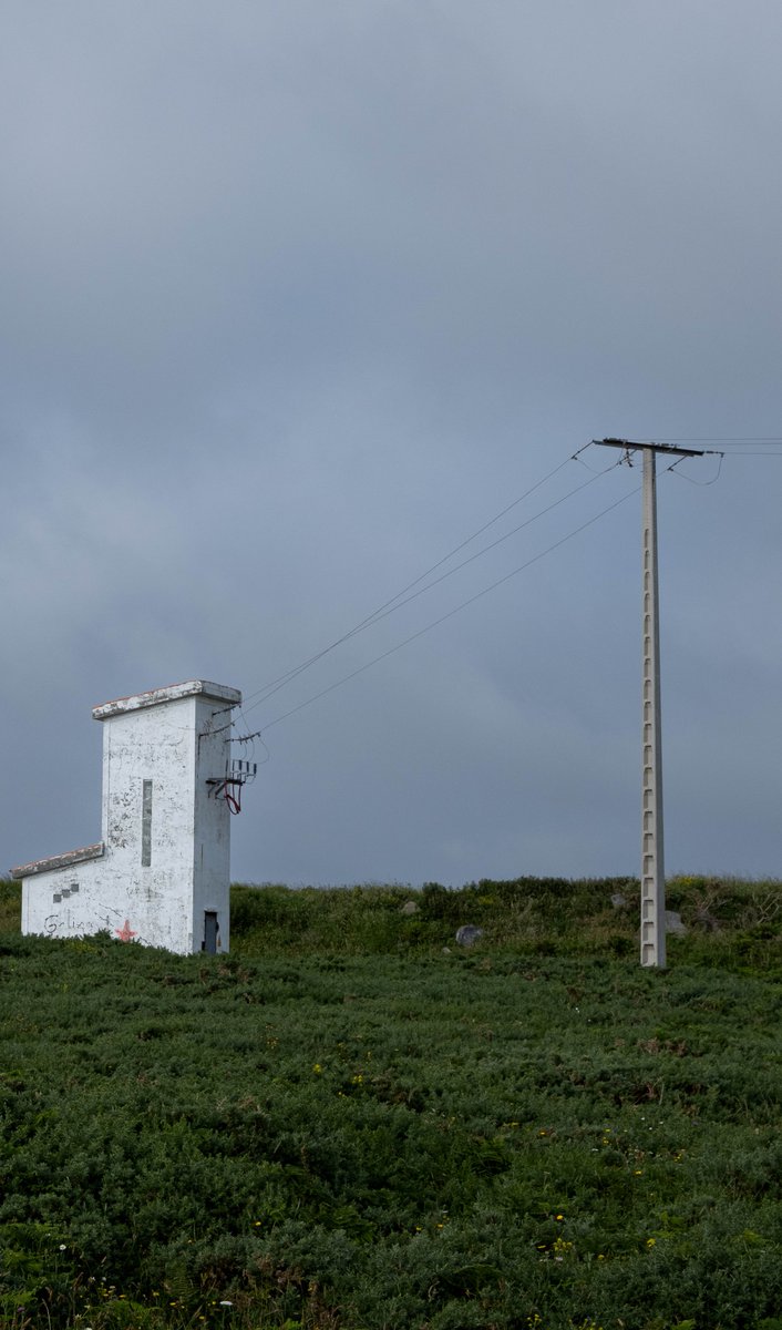 a shed and a lightpost in a field