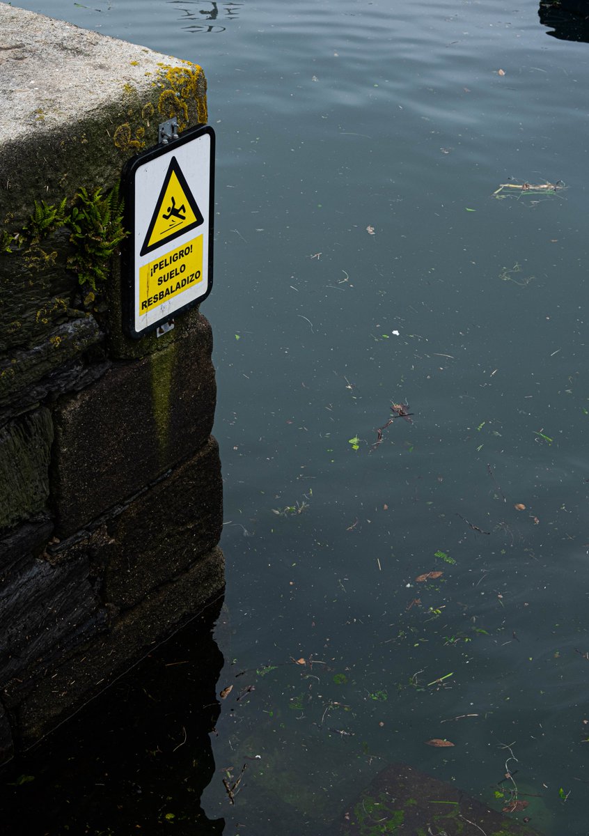 A wet floor sign over the sea